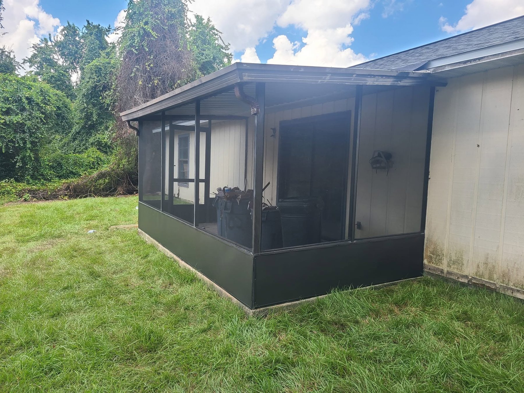 Newly rebuilt screened porch with black aluminum frame after Smith's Screen Services repair