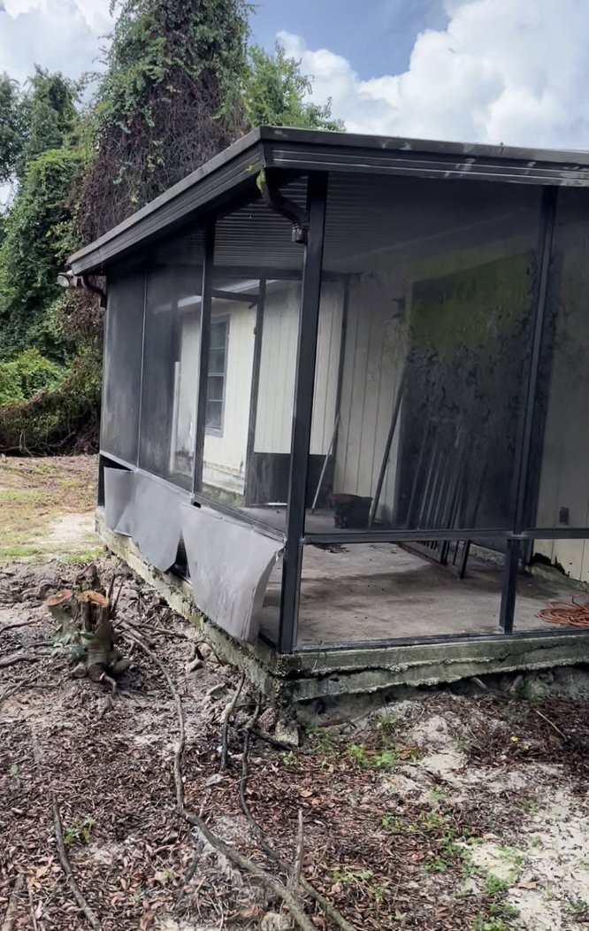 Deteriorated screened porch with collapsed screen panels before Smith's Screen Services repair