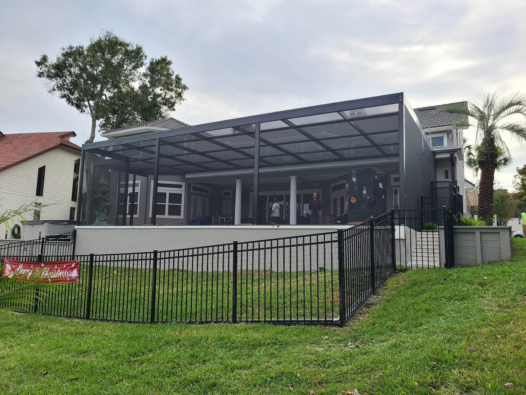 Large screened lanai enclosure spanning full rear of two-story Florida home