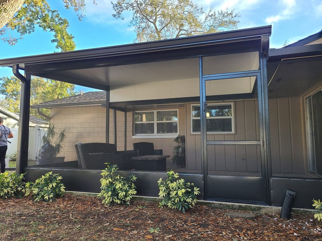 Covered patio screen enclosure attached to mid-century Florida home