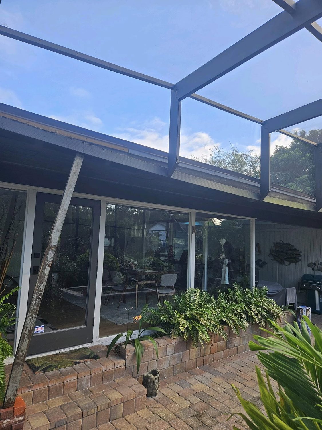Screened patio addition install in progress with ladder against roofline